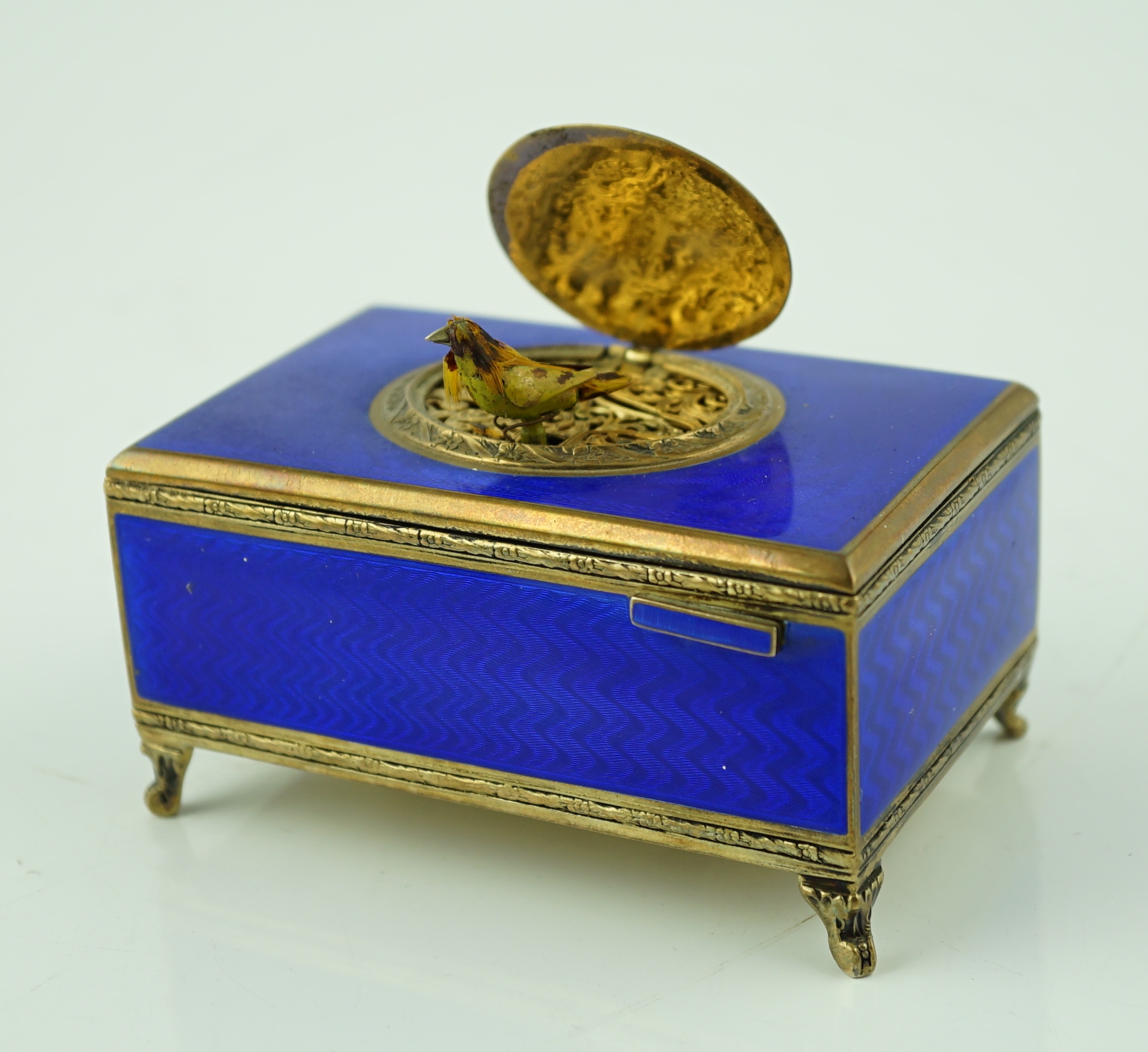 An early 20th century sterling silver gilt and blue guilloche enamelled rectangular singing bird box